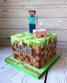 a cake made to look like a minecraft block with a man standing on top