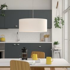 a kitchen with a table, chairs and a coffee pot on the dining room table