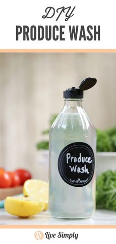 a bottle of produce wash sitting on top of a counter next to lemons and tomatoes