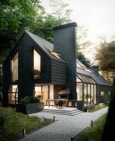 a black house with lots of windows in the front and side of it, surrounded by greenery