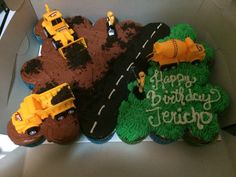 three decorated birthday cakes in the shape of construction trucks and tractors on a road with trees