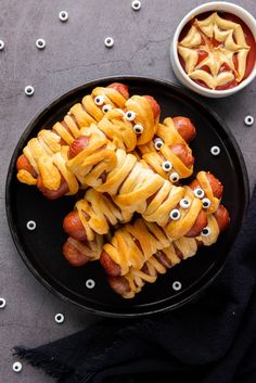 some food is on a black plate with googly eyes and eyeballs around them