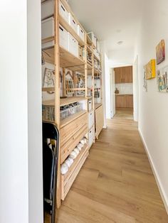 a long hallway with wooden shelves and white walls