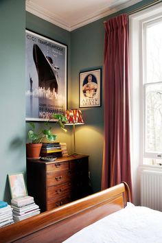 a bed room with a neatly made bed and a poster on the wall above it