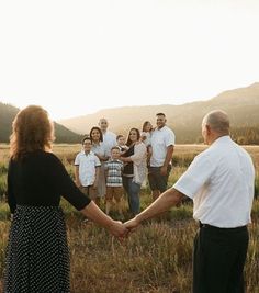 a group of people standing in a field holding hands