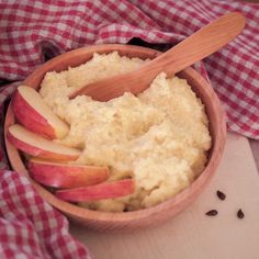 an apple and oatmeal bowl with spoon in it on a checkered cloth