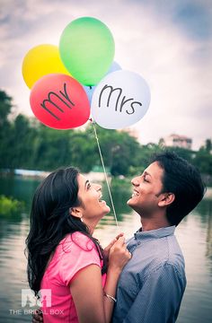 a man and woman holding balloons with the word mr and mrs written on one balloon