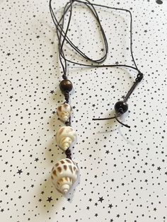 the necklace is made up of shells and black beads on a star patterned tablecloth