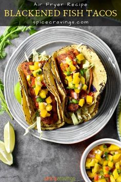 three fish tacos on a plate with mango salsa