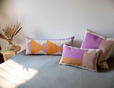 three decorative pillows on a bed in a bedroom