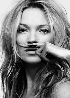 a black and white photo of a woman with fake moustache