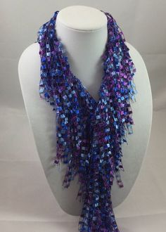 A beautiful and unique handmade accessory that shimmers and portrays a beaded look! Each Fringed Scarf Necklace is handmade and can be worn multiple ways. Item is lite weight and is available in many stunning great colors. Comes packaged in an organza bag. A great gift item. Fringed Scarf Necklace is approx. 66 inches in length and is made of 97% Nylon and 3% Lurex. Handwash in cold water and lay flat to dry. Each item is made by hand and slight variations may occur. Handmade Lariat Beaded Necklace For Party, Blue Lariat Jewelry For Party, Blue Distinctive Necklaces For Party, Blue Necklaces With Unique Variations For Parties, Blue Necklace With Unique Variations For Party, Blue Lariat Necklace For Party, Handmade Purple Beaded Necklaces For Party, Handmade Purple Beaded Necklace For Party, Blue Iris