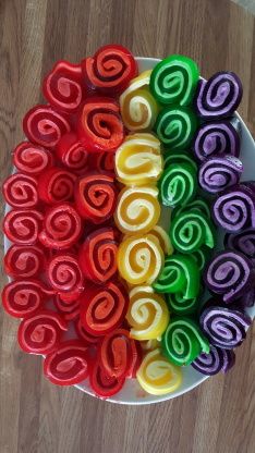 a bowl filled with lots of different colored waxed paper rolls on top of a wooden table