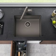 an overhead view of a kitchen sink with utensils on the counter top and other items around it