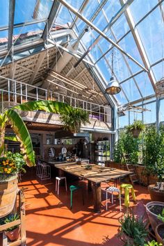 the inside of a greenhouse with tables, chairs and potted plants in pots on the floor