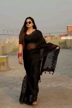 a woman in a black sari walking down the street