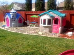 there is a play area in the backyard with plastic houses and children's toys