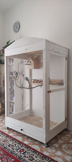 a white bird cage sitting on top of a rug