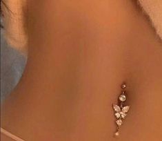 the back of a woman's stomach with a diamond butterfly pin on her left side