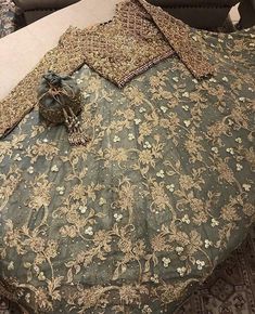 the bed is made up with an intricately designed comforter and matching pillow cases