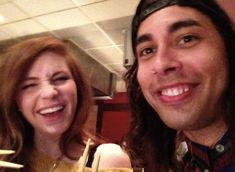 a man and woman are smiling for the camera with drinks in front of their faces