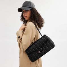 A modern take on an archival 1970s Coach design our structured Tabby shoulder bag is crafted of luxe quilted nappa leather. Finished with our Signature hardware for an iconic touch the 33 is a spacious style with a secure inside zip pocket a convenient outside pocket and plenty of room for essentials including a mini tablet. Keep the leather-and-chain strap long to wear it crossbody or double it for a shorter dressier look. | Coach Tabby Shoulder Bag 33 With Quilting - Women's - Pewter/black Coach Hamdbags, Luxury Handbags Coach, Coach Handbags Coach, Trendy Coach Shoulder Bag, Coach Pillow Tabby Purse, Coach Bag Blck, Black Crossbody Bag Coach, Coach Bags 2021, Coach Pillow Tabby Gray