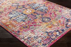 a colorful area rug with an ornate design on the top and bottom, along with dark wood flooring