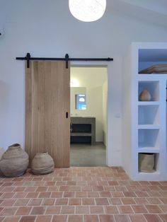 two vases are sitting on the floor in front of a sliding door that leads to an office