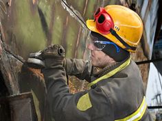 a man in safety gear painting on the side of a building