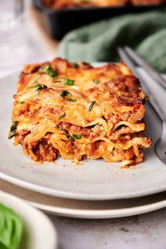 a white plate topped with lasagna covered in cheese