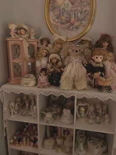 there are many dolls and figurines on the shelf