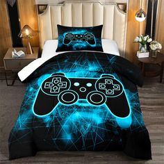 a bed covered in a black and blue comforter with two video game controllers on it