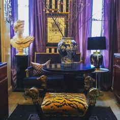 a living room filled with furniture and a large vase on top of a wooden table