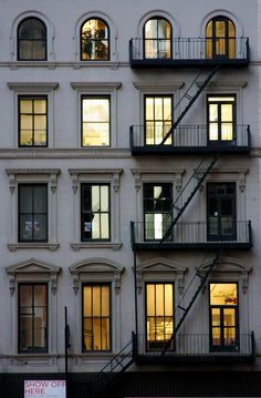 an apartment building with many windows and balconies at night, framed in black frame