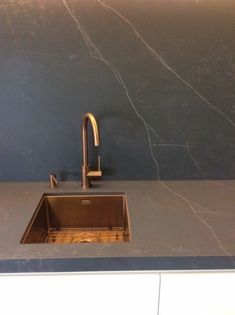 a kitchen sink sitting under a faucet next to a counter