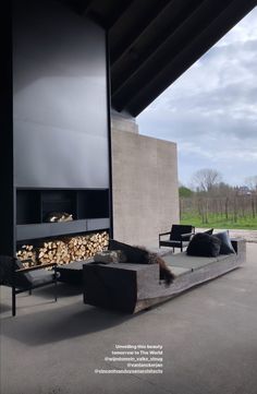 a living room with a couch and firewood stacked on the wall next to it