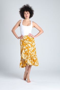 Lovely yellow floral crossover skirt, perfect for any occasion. You can pair it with sneakers for a sporty look or dress it up with heels and a special top. This crossover skirt fastens with a custom button and adjustable straps attached to the skirt, allowing you to adjust it perfectly to your waist. The floral print is a timeless classic that never goes out of style. These types of skirts are wardrobe essentials that everyone should have. Each skirt is handmade and tailored to ensure you feel Floral Print Tiered Skirt For Beach Season, Flowy Midi Wrap Skirt For Vacation, Floral Print Wrap Skirt For Vacation, Beach Asymmetrical Skirt With Floral Print, Yellow Flowy Ruffled Maxi Skirt, Flowy Yellow Ruffled Maxi Skirt, Yellow Maxi Skirt For Day Out, Summer Asymmetrical Wrap Skirt With Floral Print, Yellow Skirted Summer Bottoms