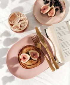 a pink plate topped with food next to a fork and cup filled with watermelon