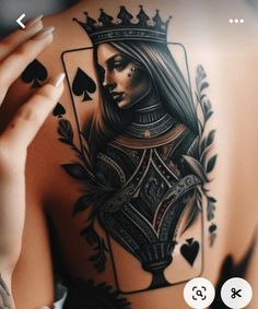 the back of a woman's body with tattoos on it and playing cards in front of her