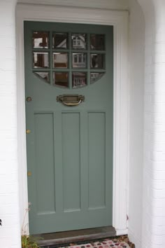 an image of a green front door with glass inserts on the top and bottom