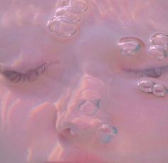 a woman's face is covered in bubbles and has her eyes closed to the side