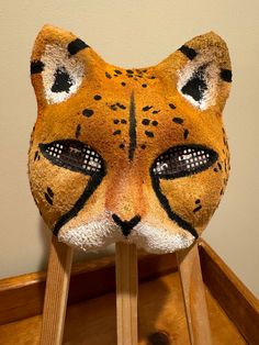 a close up of a cat mask on a wooden stand