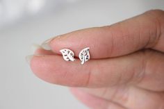 "This listing is for a pair of tiny leaf earrings. For a single stud earring, please visit the section \" One stud \" in my shop www.etsy.com/your/shops/GreatJewelry4All/sections/14235940 These cute studs are measured 5 x 8 mm . They are made of 925 sterling silver ( not silver plated) so they are safe for you if you have an allergy, come with sterling silver butterfly earnuts. Available in Silver The item wil be sent in a gift box. --------------------------------------------------------------- Minimalist Silver Leaf Earrings, Silver Leaf Minimalist Earrings, Dainty Tiny Silver Cartilage Earrings, Silver Leaf-shaped Minimalist Earrings, Simple Small Silver Earrings, Dainty Small Silver Earrings, Simple Tiny Silver Cartilage Earrings, Tiny White Sterling Silver Earrings, Minimalist Leaf-shaped Sterling Silver Earrings