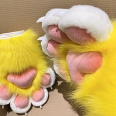 a close up of a stuffed animal's foot with yellow and pink fur on it