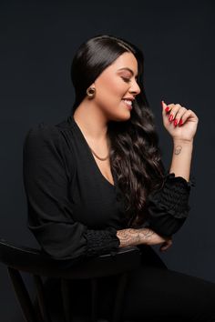 a woman sitting on top of a wooden chair