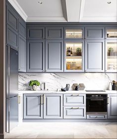 a kitchen with gray cabinets and marble counter tops