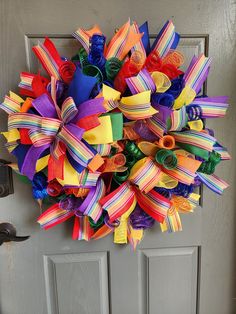 a multicolored wreath on the front door is decorated with colorful streamers and ribbons