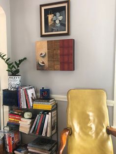 a yellow chair sitting next to a book shelf filled with books