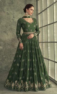 COLOR : Dark Mehendi Green FABRIC : Top - Pure Viscose Silk, Inner - Can Can, Dupatta - Chiffon/Net WORK : Zari, Woven Embroidery, Embroidered Waist Belt, Tassels, Embellished Lace BorderOCCASION : Wedding, Reception, Mehendi, Engagement, Party Wear, Festival READY-TO-WEAR : No STITCHING : Available as semi-stitched fabric, can be stitched using standard size option (+$20). Note: There might be a slight color variation due to lighting and flash used during photoshoot. The bright shade seen is th Art Silk Anarkali Set With Long Sleeves For Reception, Anarkali Art Silk Salwar Kameez With Long Sleeves, Green Anarkali Traditional Wear With Long Sleeves, Green Long Sleeve Salwar Kameez For Reception, Green Long Sleeve Anarkali Traditional Wear, Long Sleeve Anarkali Set With Intricate Embroidery, Green Long Sleeve Anarkali Set With Zari Work, Anarkali Sharara With Intricate Embroidery, Anarkali Sharara With Intricate Embroidery And Long Sleeves