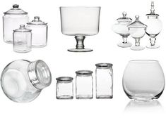 several glass objects are arranged on a white background, including vases and jars with lids